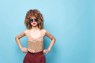 Kıvırcık saçlı, kırmızı dudaklı, koyu mavi gözlü. 