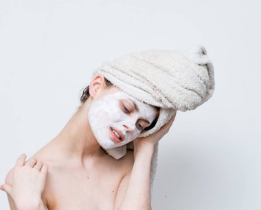 Kafasında havlu, omuzlarında beyaz maske olan komik bir kadın.