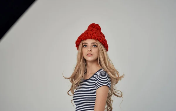 Mulher loira em t-shirt listrada e chapéu vermelho retrato sobre luz fundo recortado vista — Fotografia de Stock