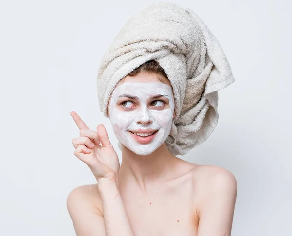 Wanita dengan bahu telanjang wajah krim handuk di kepala — Stok Foto