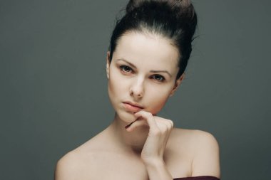 Güzel esmer, çıplak omuzlu, yüzü kıllı.