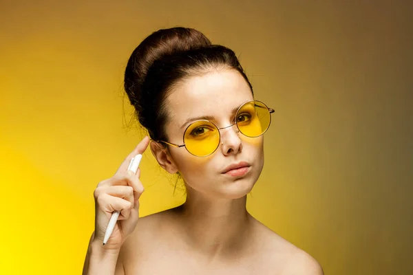 Bruna in occhiali gialli spalle nude sigaretta nelle mani emozioni — Foto Stock