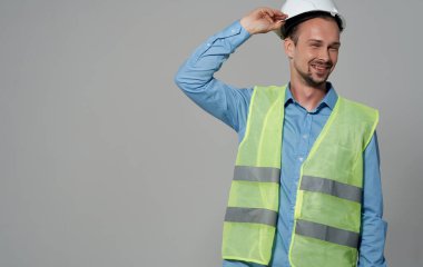 Başında miğfer olan sarı yelekli bir adam inşaat mühendisi tamir işi yapıyor.