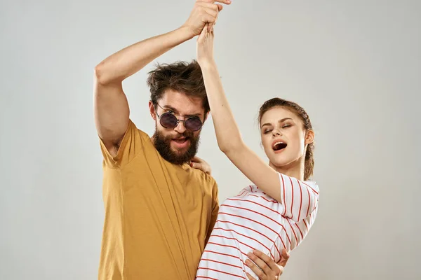 Homem em óculos de sol ao lado da mulher em listrado t-shirt emoções comunicação estúdio de moda diversão — Fotografia de Stock