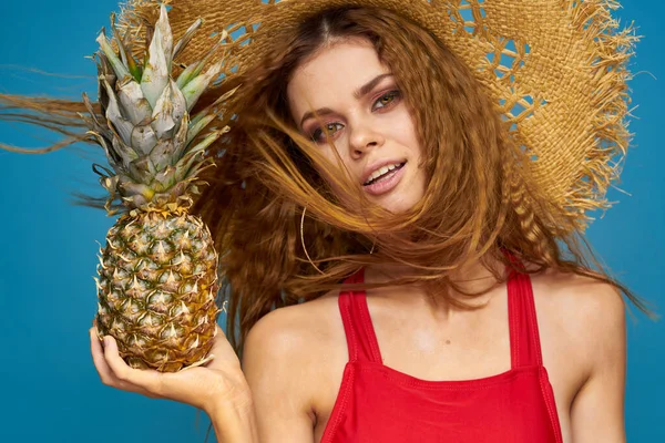 En kvinna i halmhatt med en ananas i händerna eller är det en rolig blå exotisk frukt bakgrund — Stockfoto