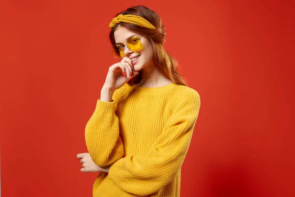 Veselá žena hippie žlutý svetr brýle emoce červené pozadí — Stock fotografie