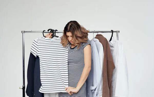 Woman in fitting room with clothes in hand shopping shirt