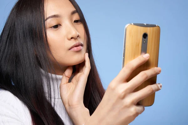 Mujer de asiático apariencia con un teléfono en manos comunicación internet tecnología —  Fotos de Stock