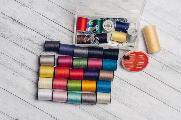 Multicolored threads and other sewing accessories on the table needles pins fastener — Stock Photo, Image