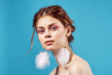 Güzel bir kadın çıplak omuzlu kozmetik küpeler lüks mavi arka plan