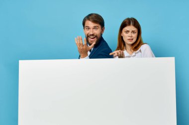 Neşeli genç çift yetkilileri sunar beyaz kağıt kopya alanı reklamları