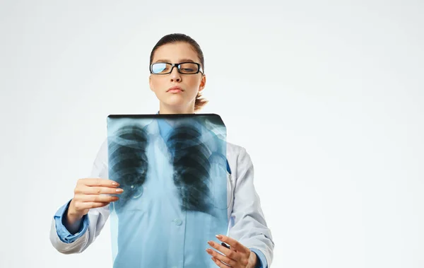 Doktor v brýlích a v lékařských šatech s rentgenem v rukou — Stock fotografie