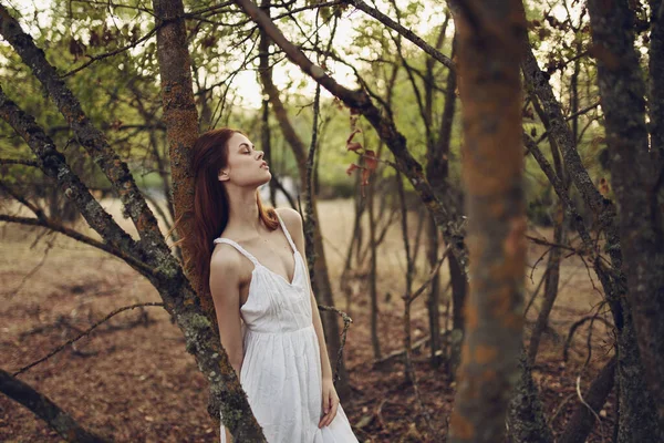 Sexy vrouw in wit zomer jurk in de buurt van bomen in de tuin — Stockfoto