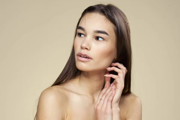 Bella donna nudo spalle cosmetici pelle pulita capelli cura sfondo beige — Foto Stock