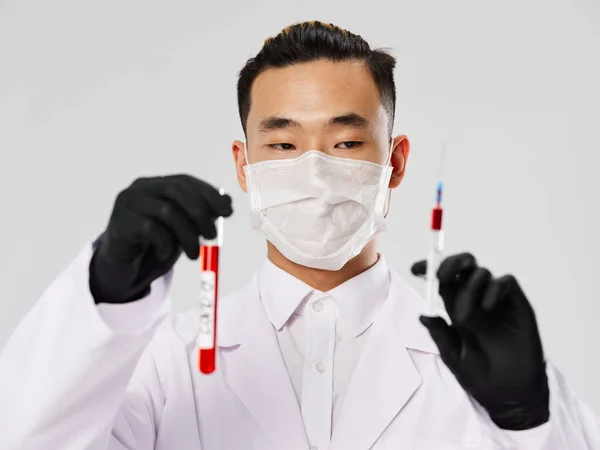 Азіатський чоловічий захисний шприц з аналізами крові. — стокове фото
