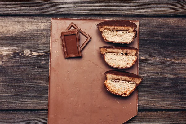 Brownie med choklad glasyr skuren på mitten och godis kuber på träbord — Stockfoto