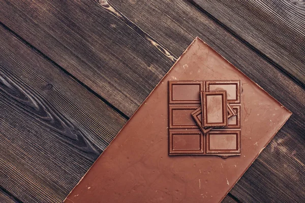 Barra de chocolate doce no fundo de madeira e doces textura de doces — Fotografia de Stock