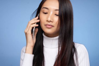 Asyalı kadın görünümlü telefon iletişim teknolojisi yaşam tarzı mavi arka plan