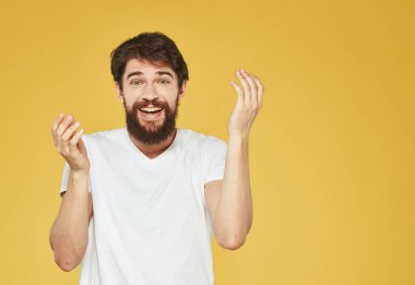 Sarı arka planda elleri ve duyguları sarı arka planda hareket eden bir adamın portresi.