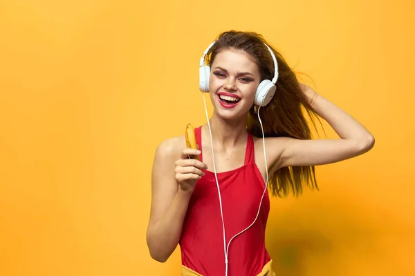 Mulher emocional em fones de ouvido brancos escuta música divertida estilo de vida fundo amarelo — Fotografia de Stock