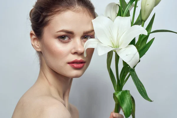 Mujer con flores blancas sobre fondo gris modo de maquillaje de primer plano retrato — Foto de Stock