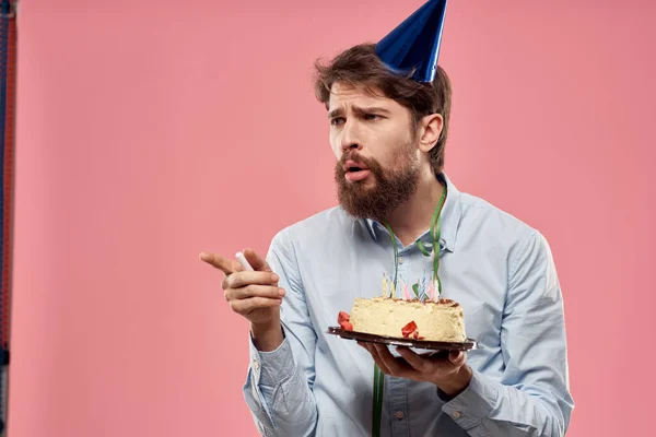 Bearded man with cake on pink background birthday party corporate emotions model loneliness