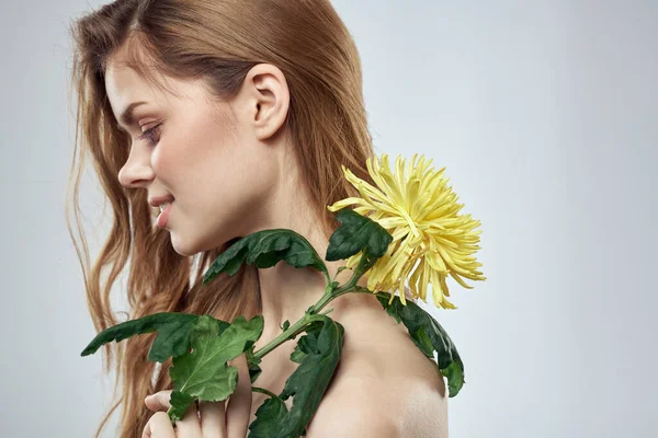 Portrét krásné ženy se žlutou květinou na světlém pozadí okouzlující úsměv model zrzavé vlasy — Stock fotografie