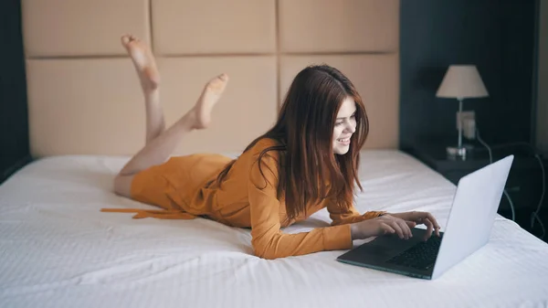 Vrouw in slaapkamer ligt in bed in de voorkant van laptop bericht rust — Stockfoto