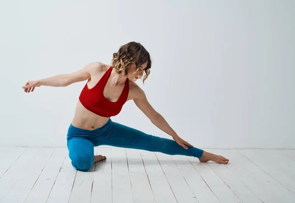 Sport kvinna yoga asana meditation i ett ljust rum gester med händerna — Stockfoto