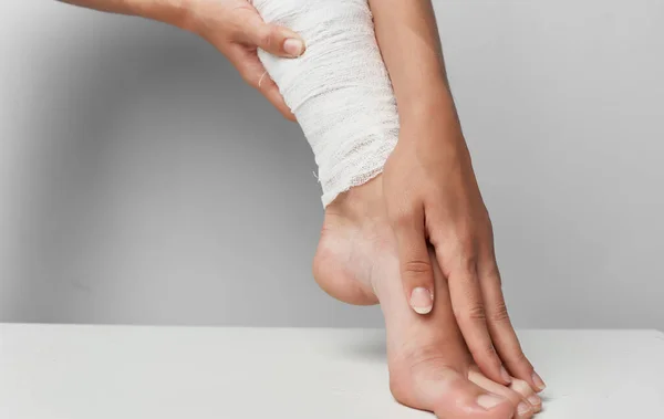 다리에 붕대를 감고 있는 다리 부상 의학 회색 배경 장애 — 스톡 사진
