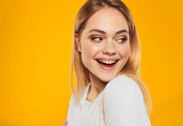 Mulher loira feliz rindo no fundo amarelo na t-shirt branca vista cortada — Fotografia de Stock