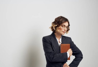 Not defterli, gömlekli, gözlüklü, kuaförlü bir kadın.