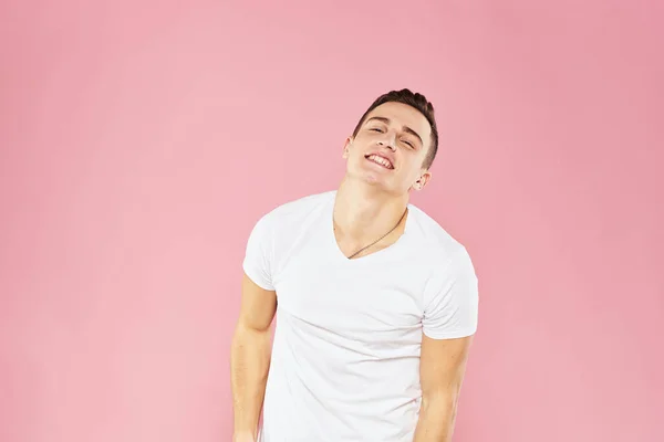 Joyeux bel homme en t-shirt blanc émotions rose fond isolé — Photo