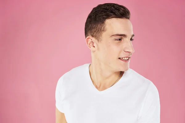 Alegre hombre guapo en blanco camiseta emociones rosa aislado fondo —  Fotos de Stock