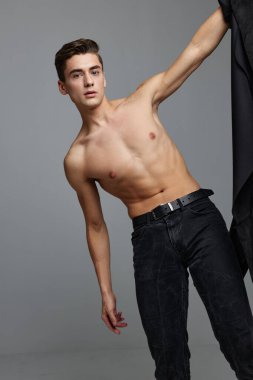 Yakışıklı adam siyah pantolonu ve göz alıcı moda stüdyosu gri arka plan yaşam tarzı modeli