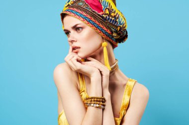 çekici bir kadın parlak makyaj dekorasyonu etnik köken çok renkli türban stüdyosu mavi arka plan