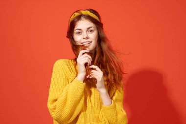 Sarı süveterli, kızıl saçlı, sevimli bir kadın.