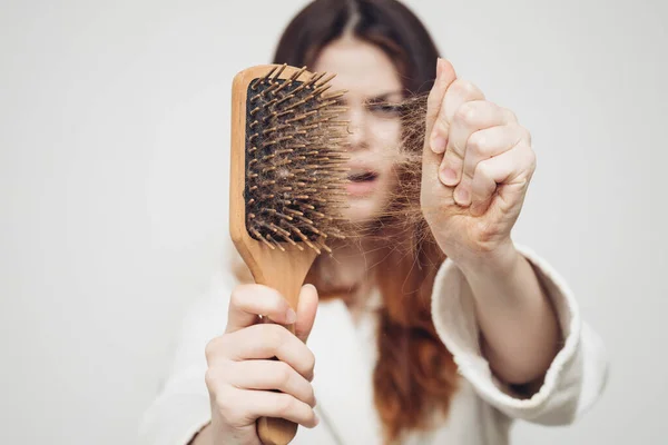 Mulher chateada remove o cabelo do pente problemas de saúde bun — Fotografia de Stock