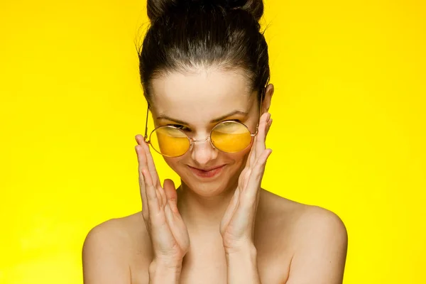 Donna con spalle nude capelli raccolti pelle chiara sfondo giallo — Foto Stock
