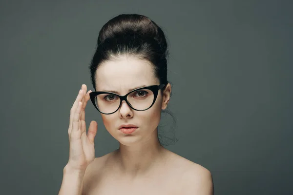 Séduisante femme aux épaules nues portant des lunettes glamour mode fond gris — Photo