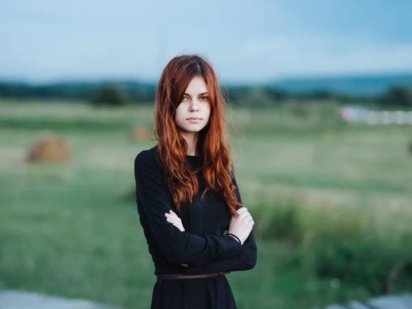 Femme aux cheveux roux en robe noire dans la nature en plein air — Photo