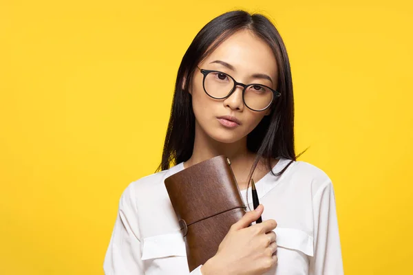 Donna di aspetto asiatico con blocco note in mano e occhiali da penna elegante stile di lavoro — Foto Stock