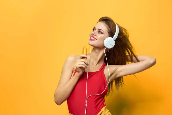 Femme émotionnelle dans les écouteurs blancs écoute de la musique fun style de vie fond jaune — Photo