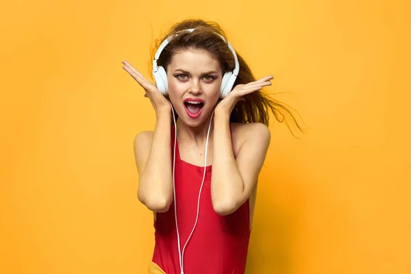 Emotional woman in white headphones listens to music fun lifestyle yellow background — Stock Photo, Image