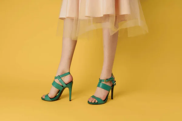 Mulheres pernas sapatos verdes sapatos de moda fundo amarelo — Fotografia de Stock