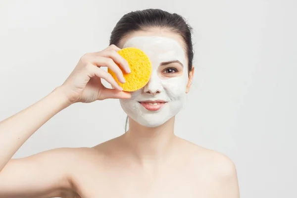 Brunette menyeka masker wajah dengan spons dipangkas tampilan — Stok Foto
