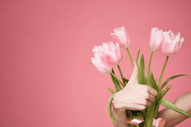 Çiçek buketi hediye olarak 8 Mart 'ta pembe arka planda