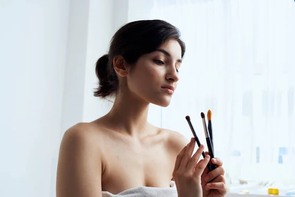 Гарна жінка в рушнику для ванної макіяжу щітка для догляду за шкірою — стокове фото