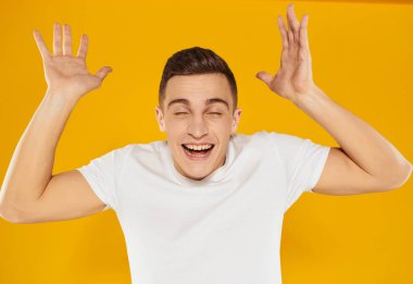 Elleri yüze yakın hareket eden adam duygusal model sarı arka plan