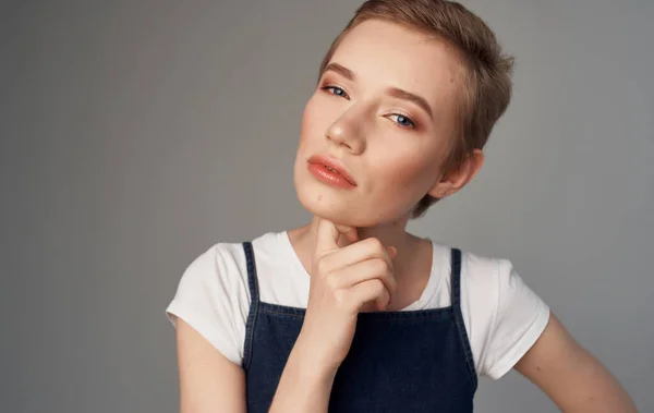 Mujer con el pelo corto Maquillaje en su cara fondo gris —  Fotos de Stock